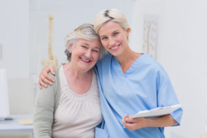 A nurse and an elderly woman posing for the camera.