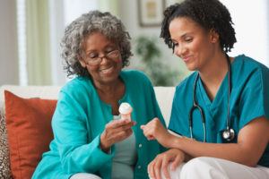 A woman and her nurse are smiling while holding something.
