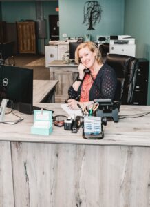 A woman sitting at the front desk of a business.